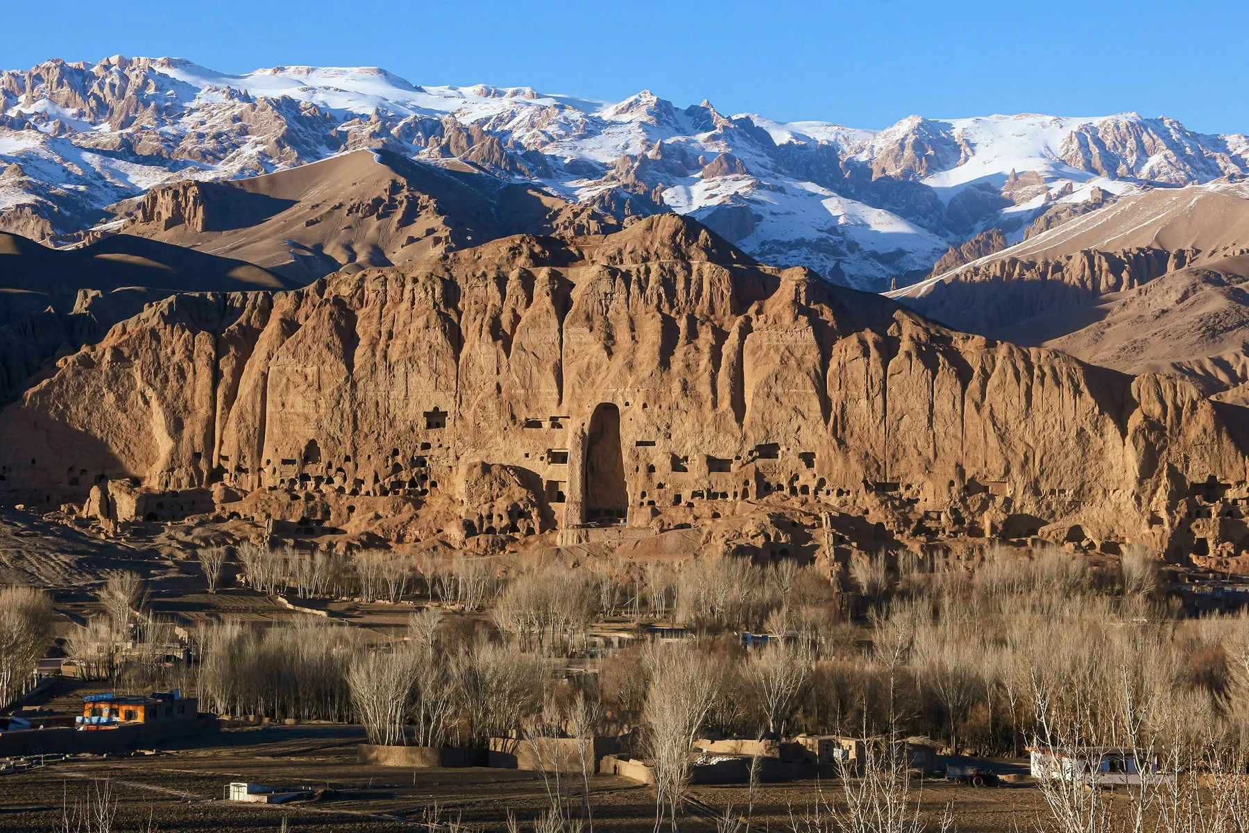 Golden eroded cliffs and snowy mountains in Upper Mustang