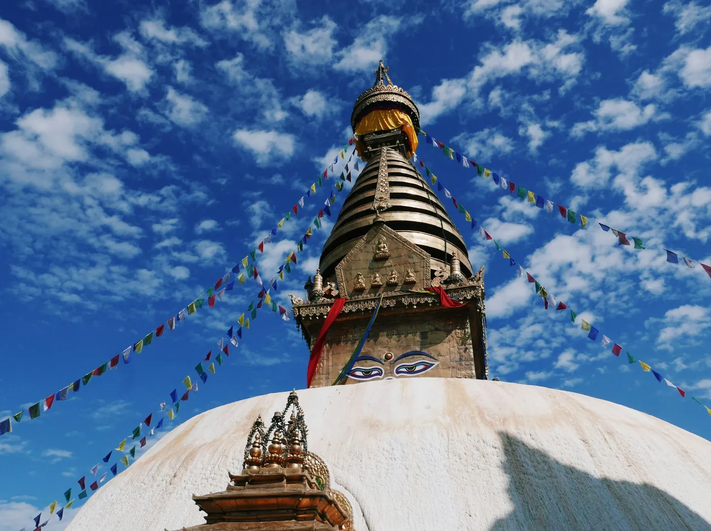 The gilded Swayambhunath stupa rising above Kathmandu beneath prayer flags