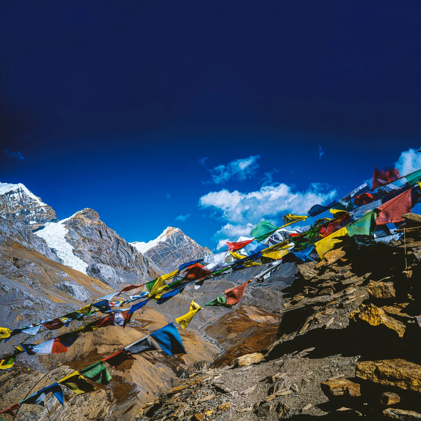 A trekker crossing a high Himalayan pass beneath snow-covered peaks
